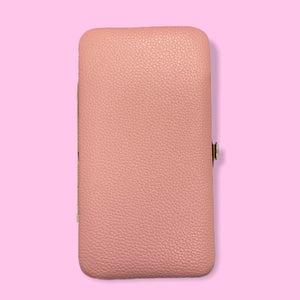a piece of luggage sitting on a pink surface 